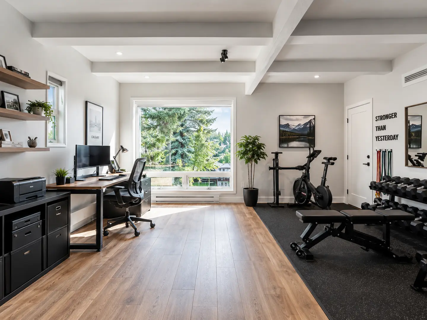 Calgary garage suite with a home office, dual monitors, exercise bike, weight bench and wide plank flooring.